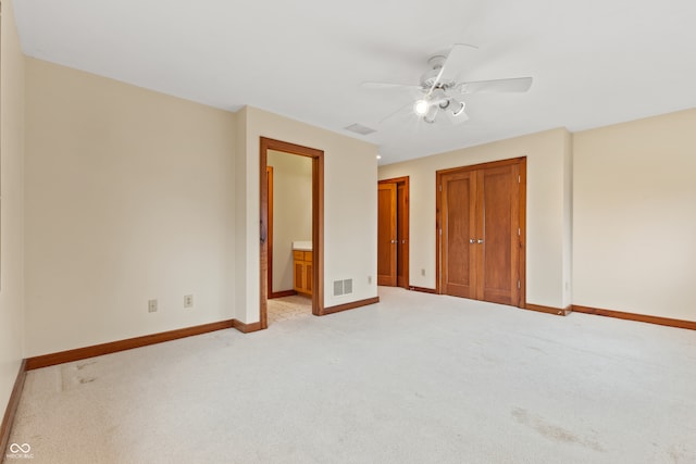 unfurnished bedroom with connected bathroom, ceiling fan, and light carpet