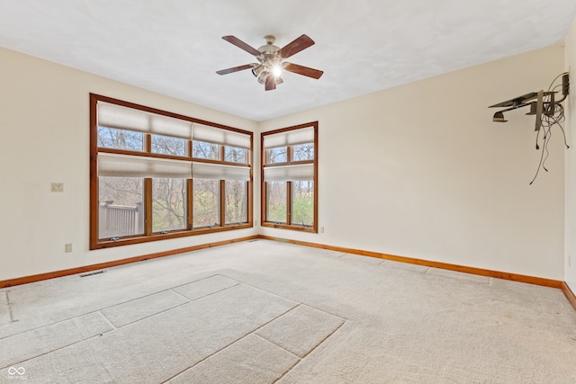 empty room with carpet flooring, plenty of natural light, and ceiling fan