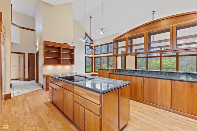 kitchen featuring a wealth of natural light, light wood-type flooring, high vaulted ceiling, and black cooktop