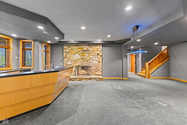 interior space with pendant lighting, carpet flooring, and a fireplace