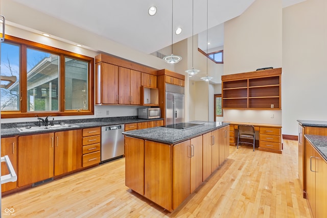 kitchen featuring a center island, sink, stainless steel appliances, and light hardwood / wood-style flooring