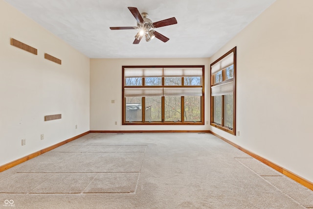 spare room with ceiling fan and light colored carpet