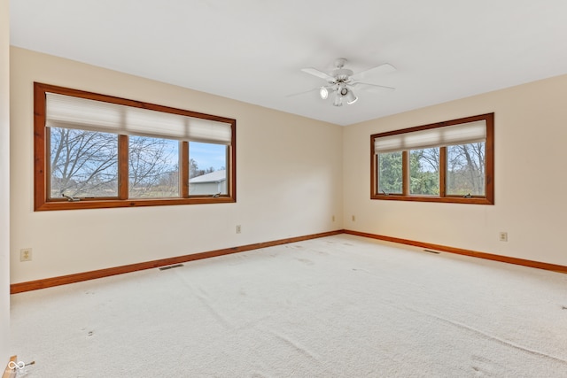 unfurnished room with carpet flooring, ceiling fan, and a healthy amount of sunlight