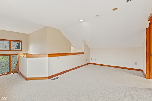 additional living space with light carpet and vaulted ceiling