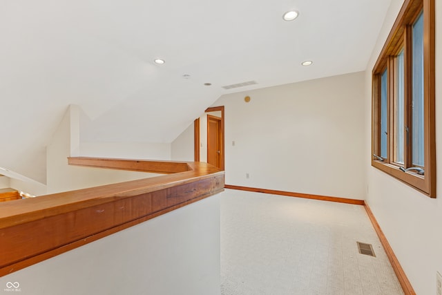 corridor with carpet and lofted ceiling