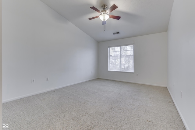 spare room featuring light carpet, ceiling fan, and lofted ceiling