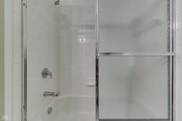 bathroom featuring bath / shower combo with glass door