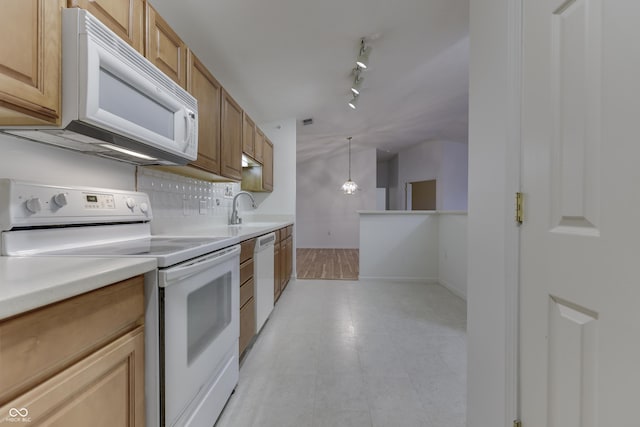 kitchen with white appliances, rail lighting, sink, hanging light fixtures, and tasteful backsplash