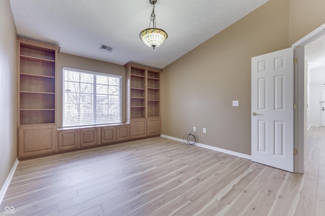 empty room with light hardwood / wood-style floors and lofted ceiling