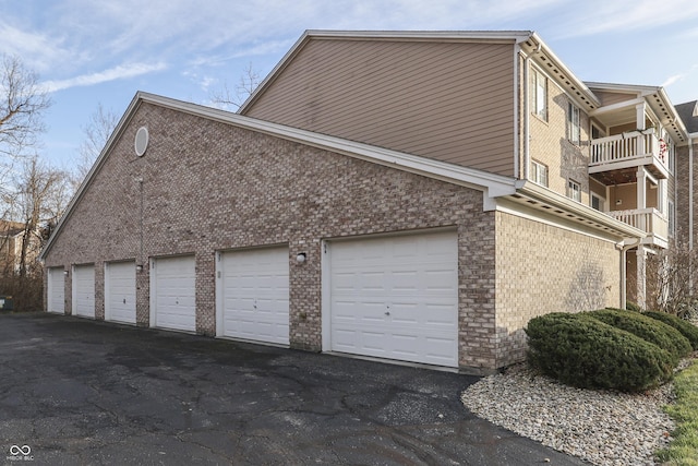 view of side of property featuring a garage and a balcony