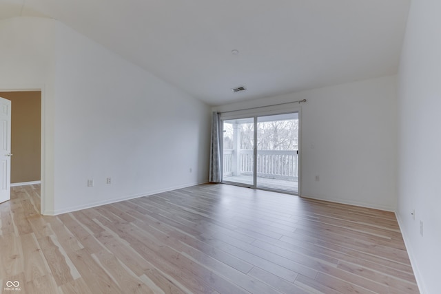 empty room with light hardwood / wood-style floors and lofted ceiling