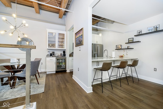 bar with wine cooler, stainless steel fridge, white cabinets, and pendant lighting