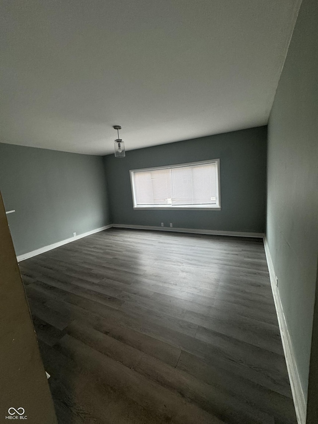 empty room with dark hardwood / wood-style flooring