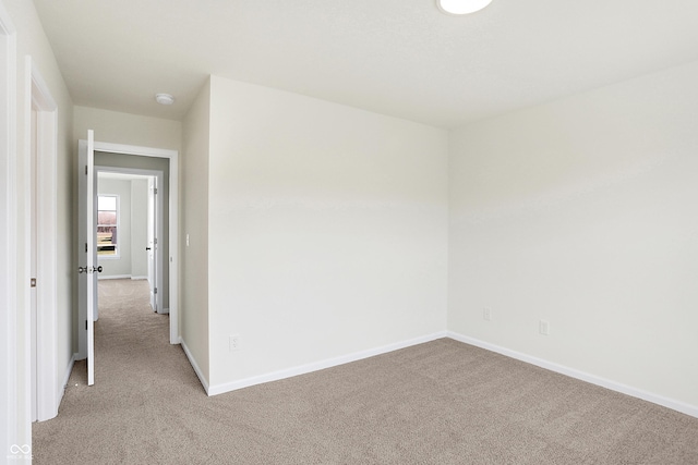 spare room featuring light colored carpet