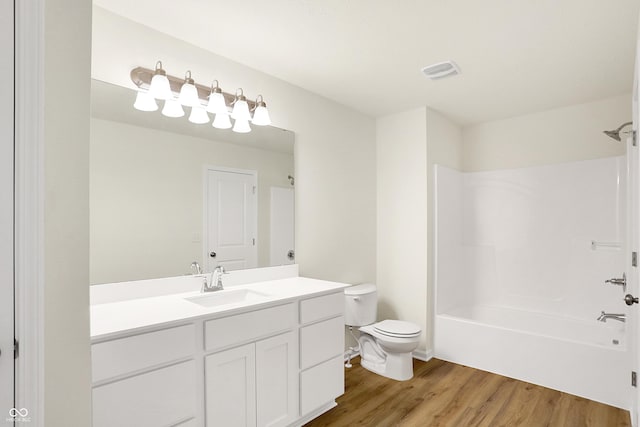 full bathroom featuring hardwood / wood-style floors, vanity, toilet, and shower / tub combination