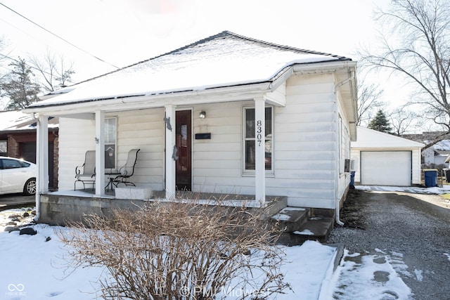 view of front facade featuring a porch, an outdoor structure, and a garage