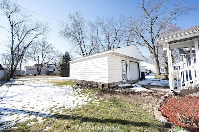 snow covered structure with a garage