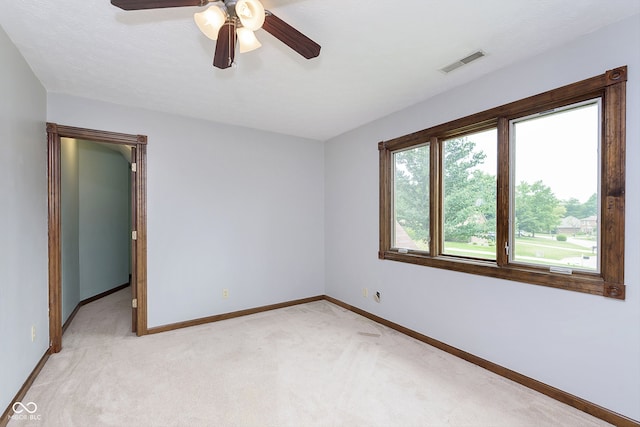 unfurnished room featuring light carpet, a textured ceiling, and ceiling fan