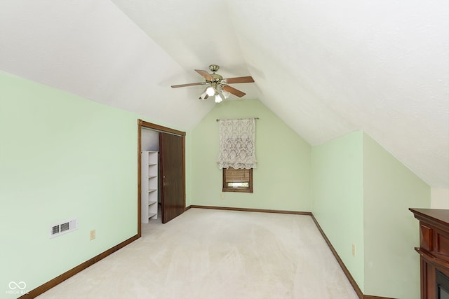 additional living space with light carpet, vaulted ceiling, and ceiling fan