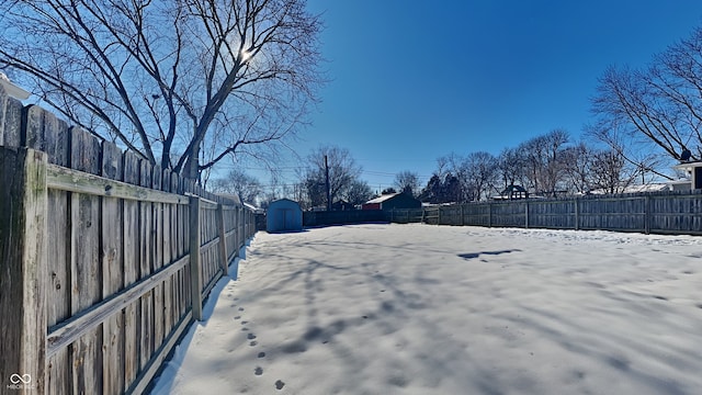 yard covered in snow featuring a shed