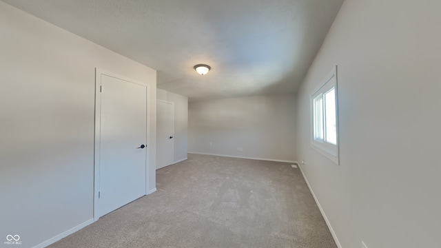 unfurnished room with light carpet