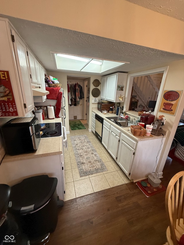 kitchen featuring white cabinetry, sink, light hardwood / wood-style flooring, dishwashing machine, and white stove