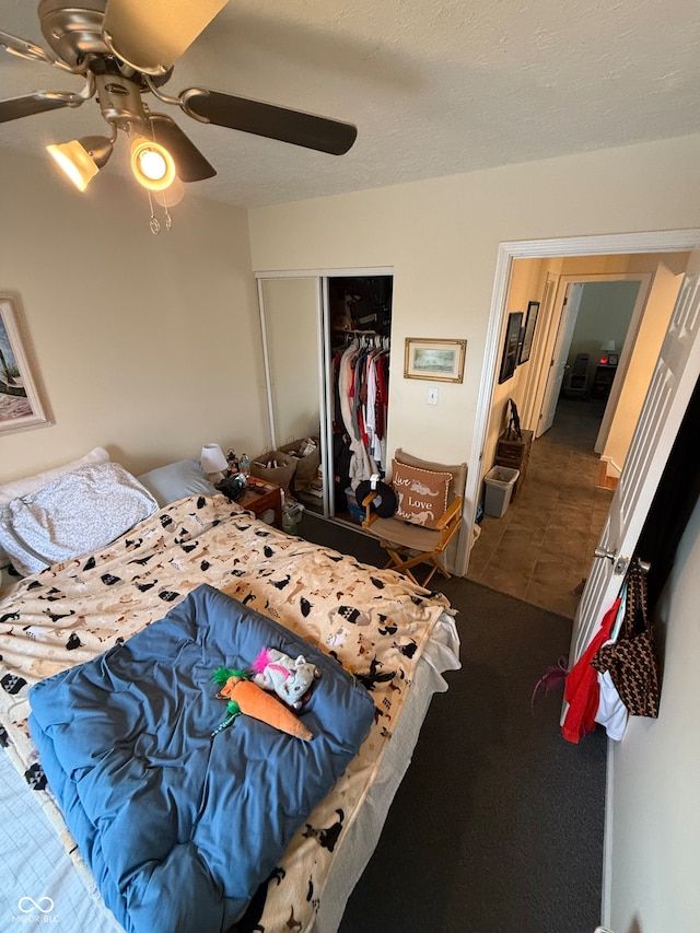 bedroom featuring ceiling fan, a closet, and a textured ceiling