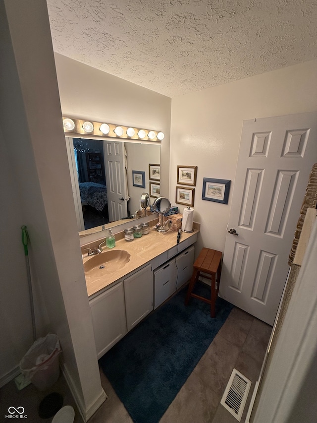 bathroom featuring a textured ceiling and vanity