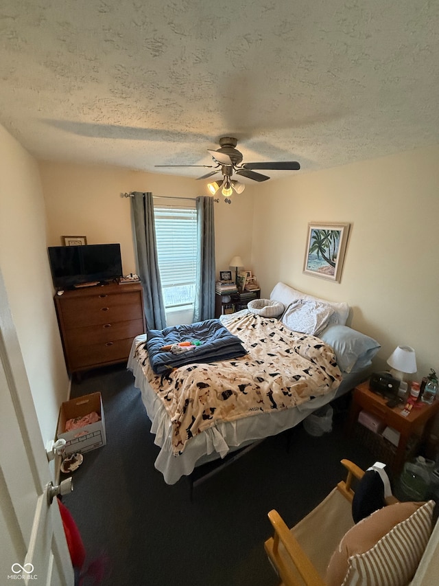 carpeted bedroom with ceiling fan and a textured ceiling