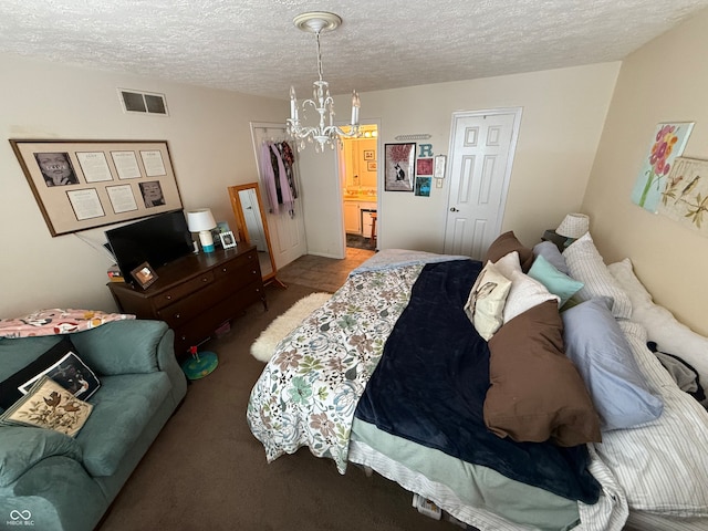 bedroom featuring a notable chandelier, carpet floors, and a textured ceiling