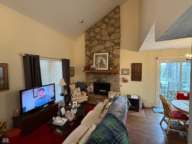 living room with a textured ceiling, dark wood-type flooring, high vaulted ceiling, a fireplace, and a chandelier