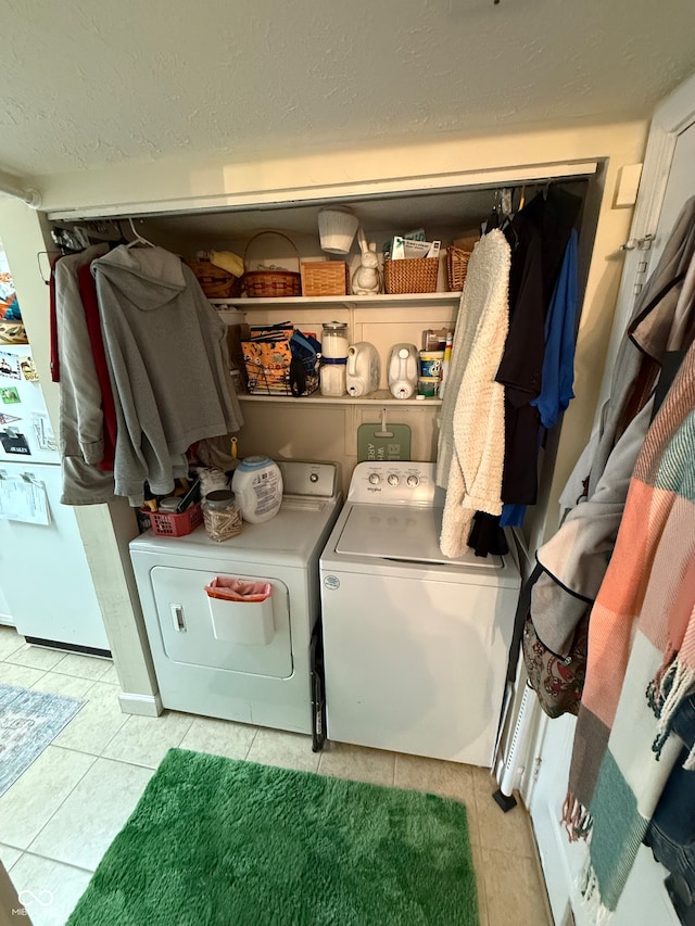 laundry area featuring light tile patterned floors and washing machine and dryer