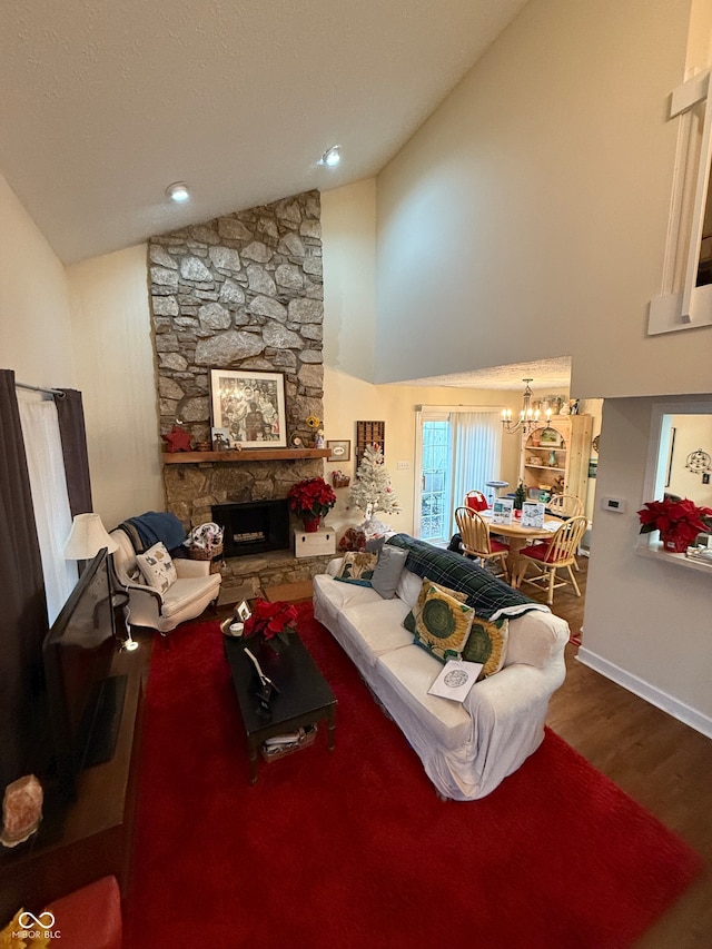 living room featuring a stone fireplace, a chandelier, high vaulted ceiling, and wood-type flooring