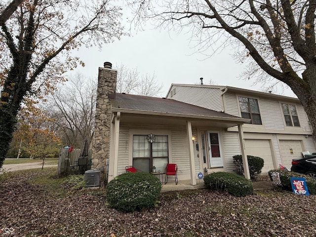 view of front of property with central AC unit and a garage