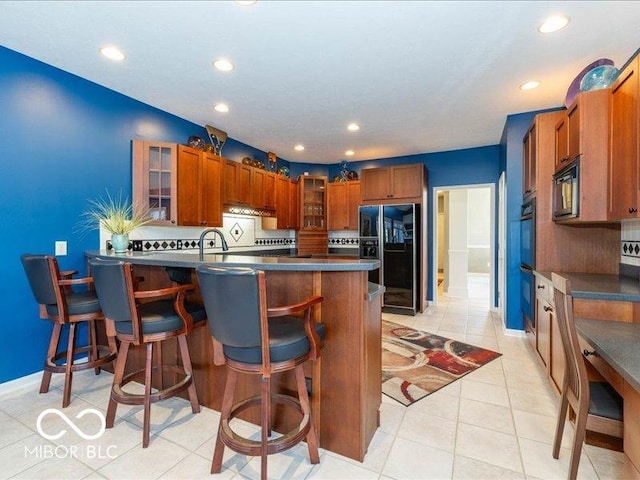 12954 Water Ridge Dr, Fishers, IN 46055 - kitchen with black appliances, glass insert cabinets, a peninsula, a kitchen breakfast bar, and recessed lighting