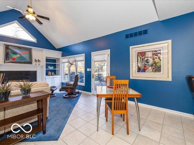 12954 Water Ridge Dr, Fishers, IN 46055 - dining space with ceiling fan, lofted ceiling, a tiled fireplace, light tile patterned floors, and baseboards
