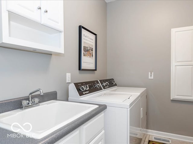 washroom featuring cabinets, separate washer and dryer, and sink