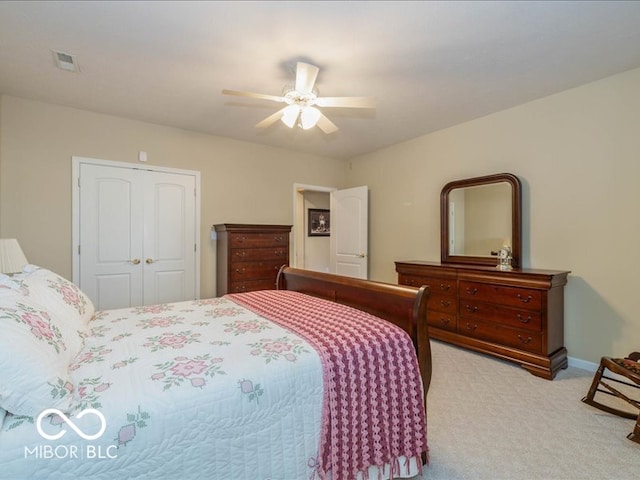 bedroom with ceiling fan, a closet, and light colored carpet