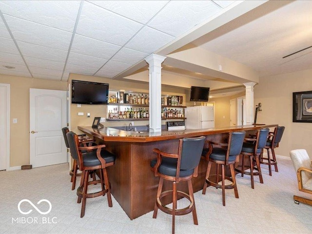 12954 Water Ridge Dr, Fishers, IN 46055 - indoor wet bar featuring freestanding refrigerator, decorative columns, carpet floors, and baseboards
