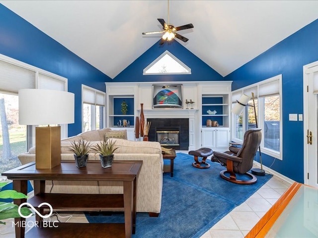 living room with a fireplace, ceiling fan, plenty of natural light, and tile patterned flooring