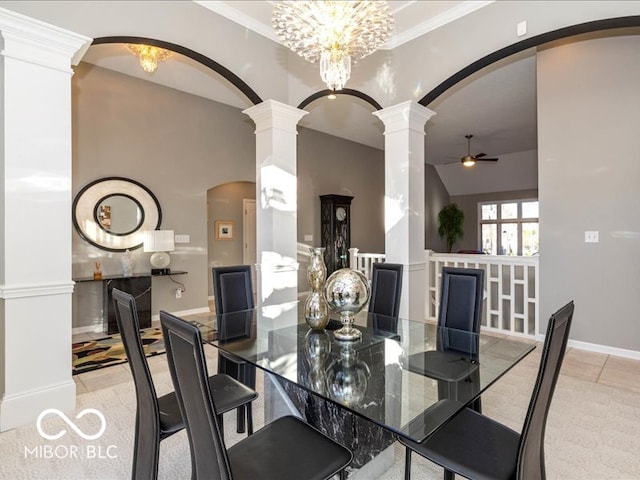 carpeted dining space featuring decorative columns, lofted ceiling, crown molding, and ceiling fan with notable chandelier