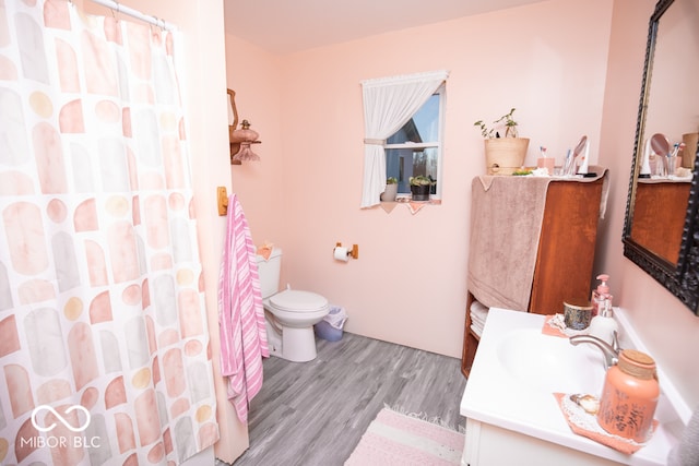 bathroom featuring toilet, vanity, a shower with shower curtain, and hardwood / wood-style flooring