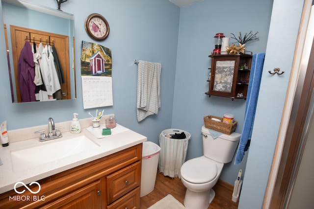 bathroom with hardwood / wood-style flooring, vanity, and toilet