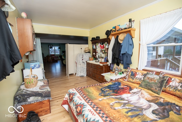 bedroom featuring light wood-type flooring and crown molding