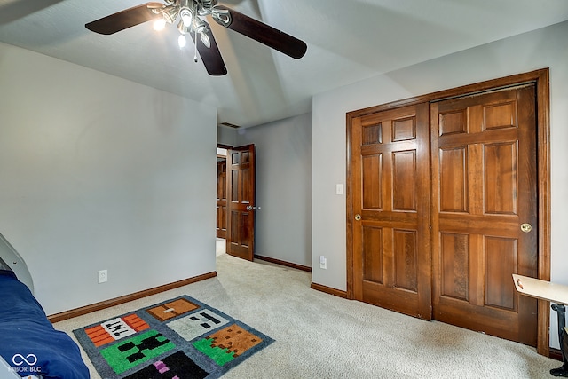 carpeted bedroom with ceiling fan and a closet