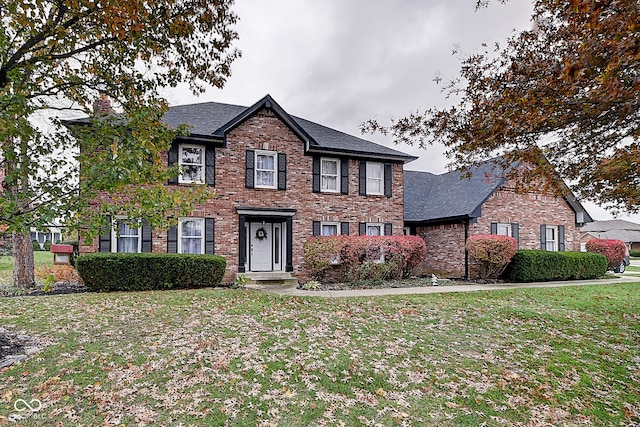 colonial inspired home with a front lawn