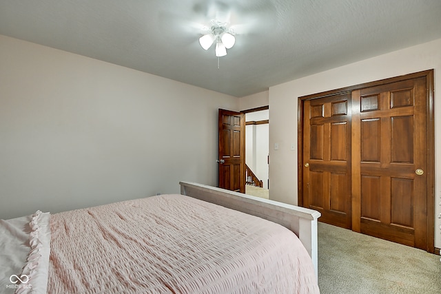 carpeted bedroom featuring ceiling fan and a closet