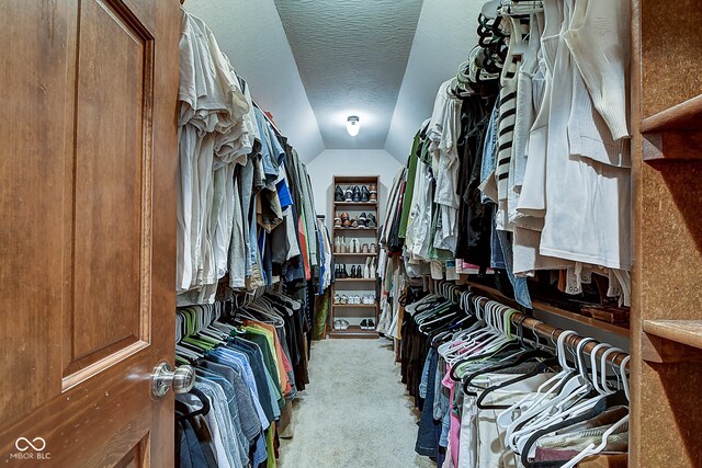 spacious closet featuring light carpet and vaulted ceiling