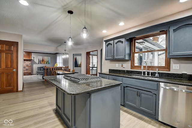 kitchen featuring stainless steel appliances, sink, light hardwood / wood-style flooring, a center island, and hanging light fixtures