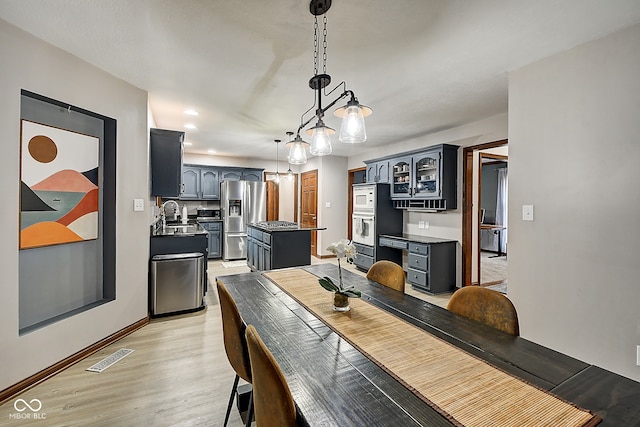 dining area with light hardwood / wood-style floors and sink